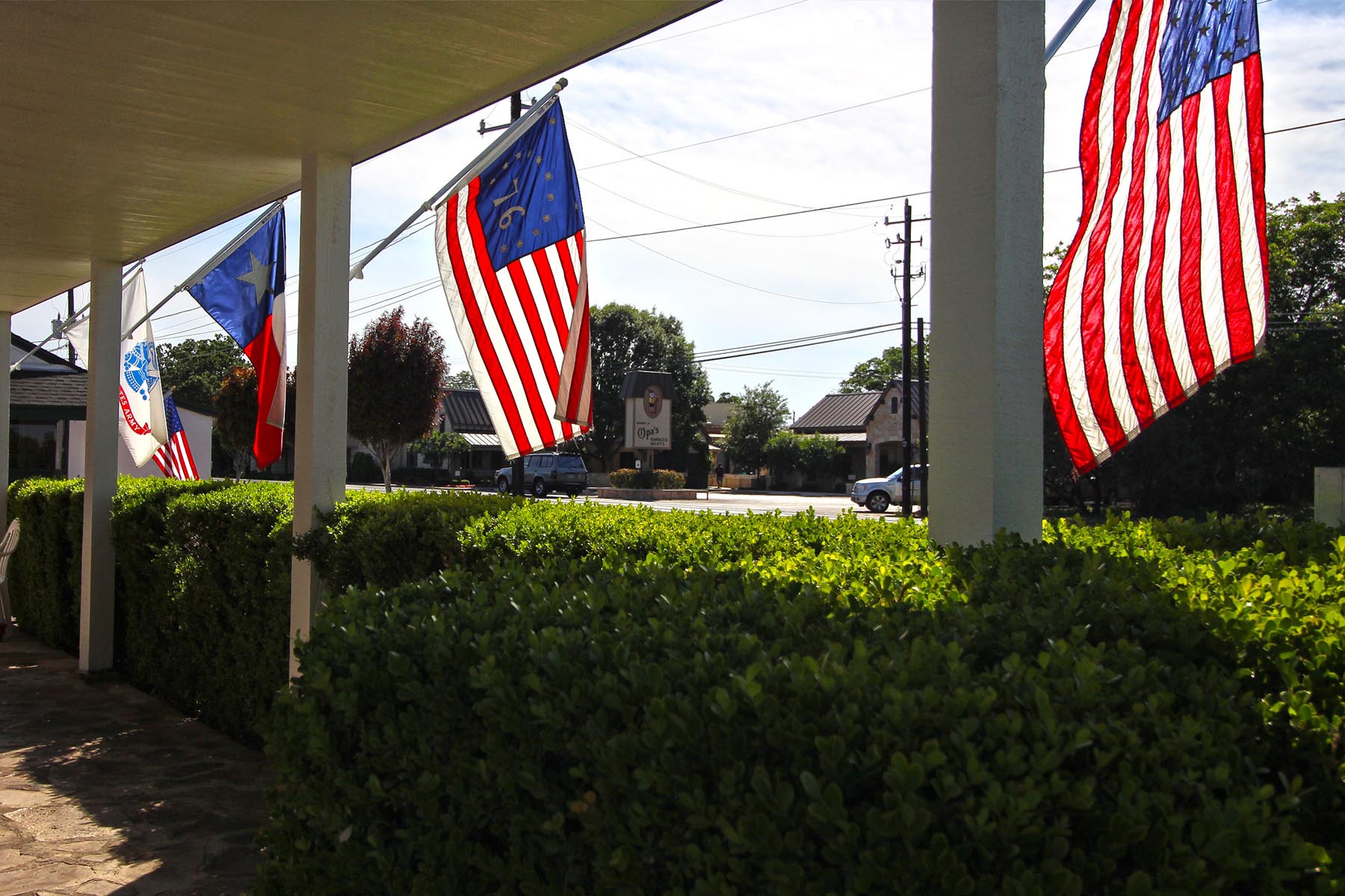 American and Texas flags hung from Peach Tree Inn.