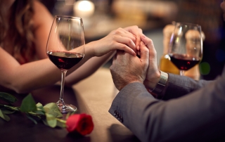 Couple holding hands during romantic dinner.