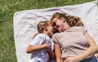 Visit Lady Bird Johnson Municipal Park in Fredericksburg, TX: A mother and daughter laying on a picnic blanket